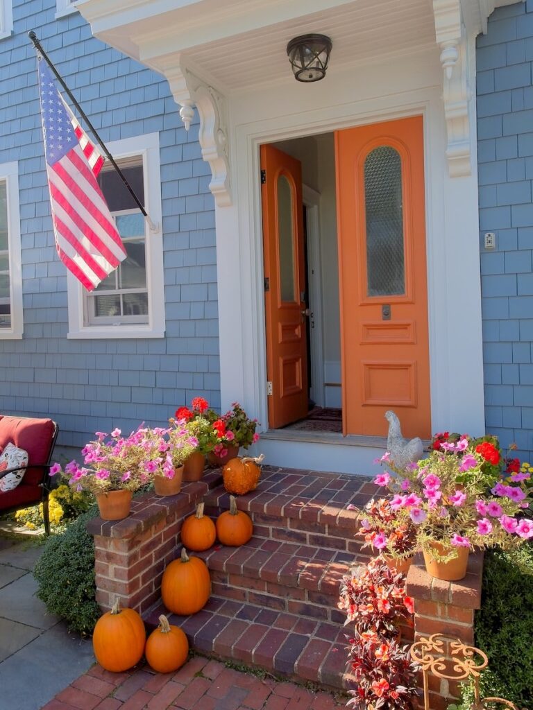 North Shore Massachusetts Home front entranceway with the US Flag, pumpkins and autumn flowers