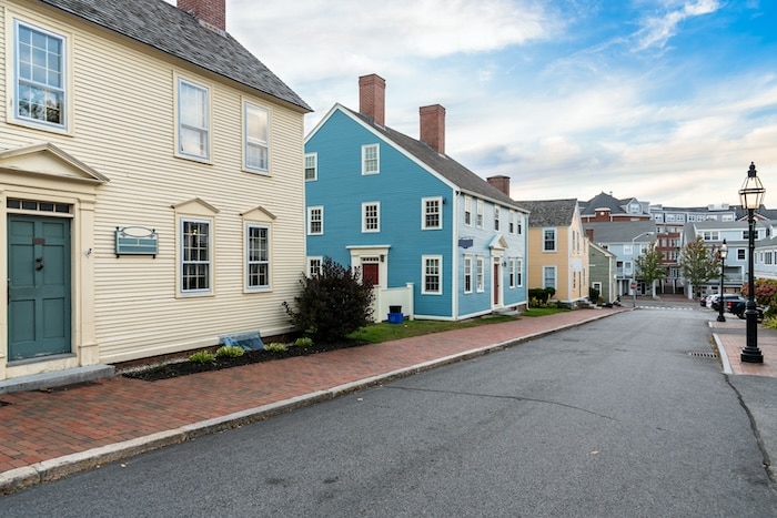 Angled view of a street lined with traditional New England detached homes